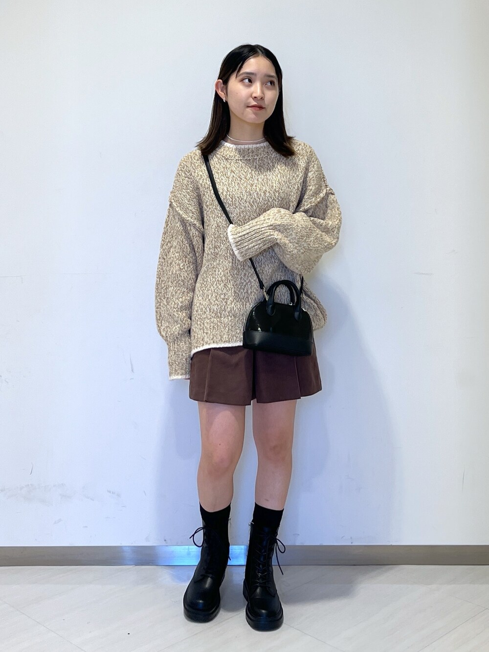 ベージュ系のニット/セーター、ブラック系のショルダーバッグ、ブラウン系のその他パンツを着用したレディースの冬コーディネートの2枚目の写真