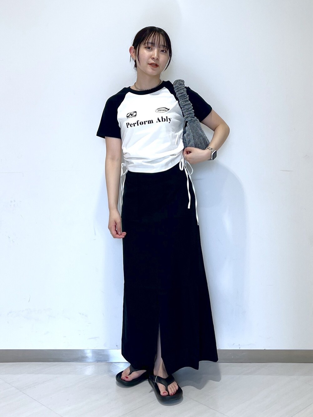 ホワイト系のTシャツ/カットソー、シルバー系のハンドバッグ、ブラック系のスカートを着用したレディースの夏コーディネートの5枚目の写真