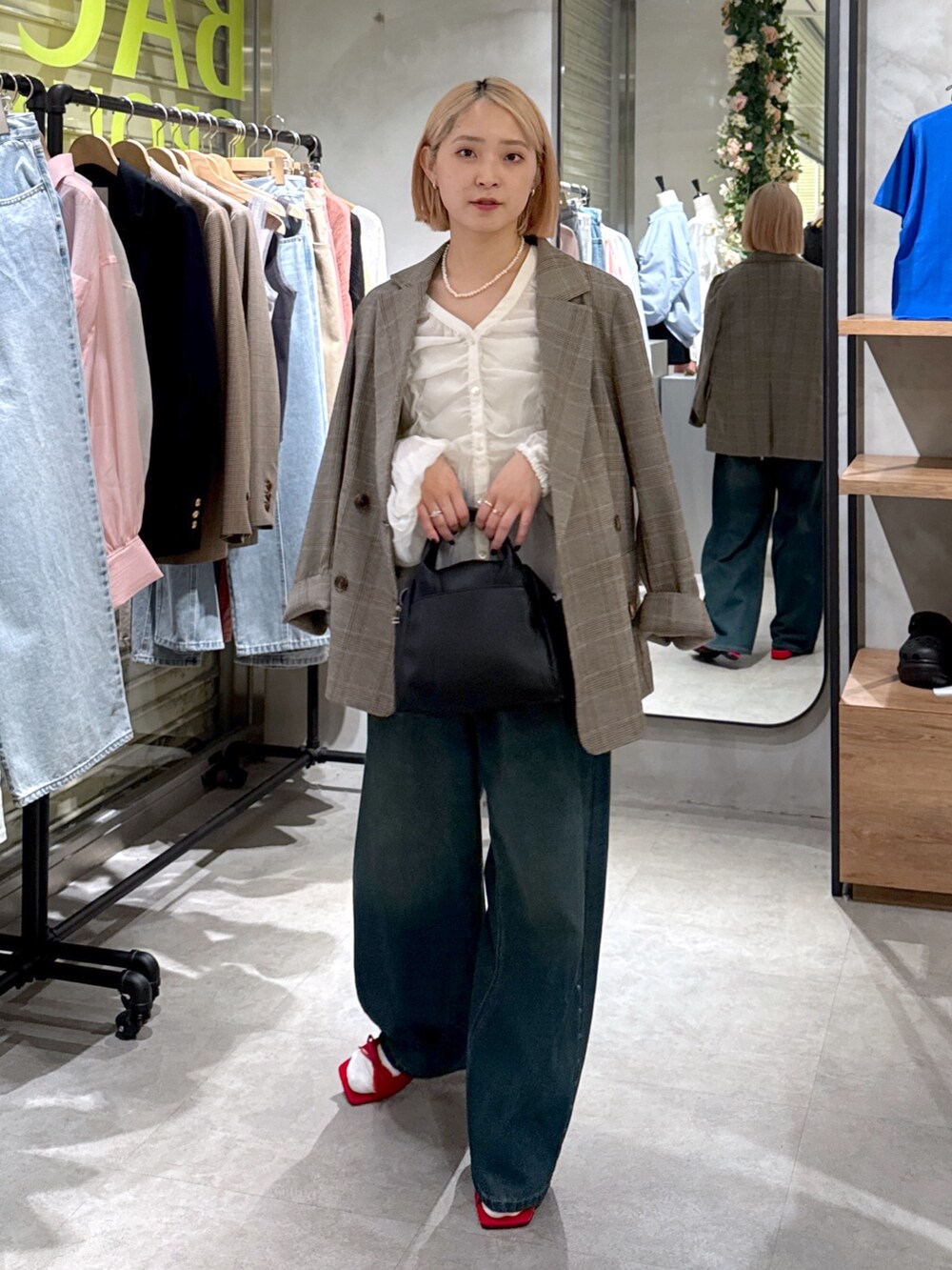 グレー系のテーラードジャケット、ホワイト系のシャツ/ブラウス、ブルー系のデニムパンツを着用したレディースの夏コーディネートの4枚目の写真