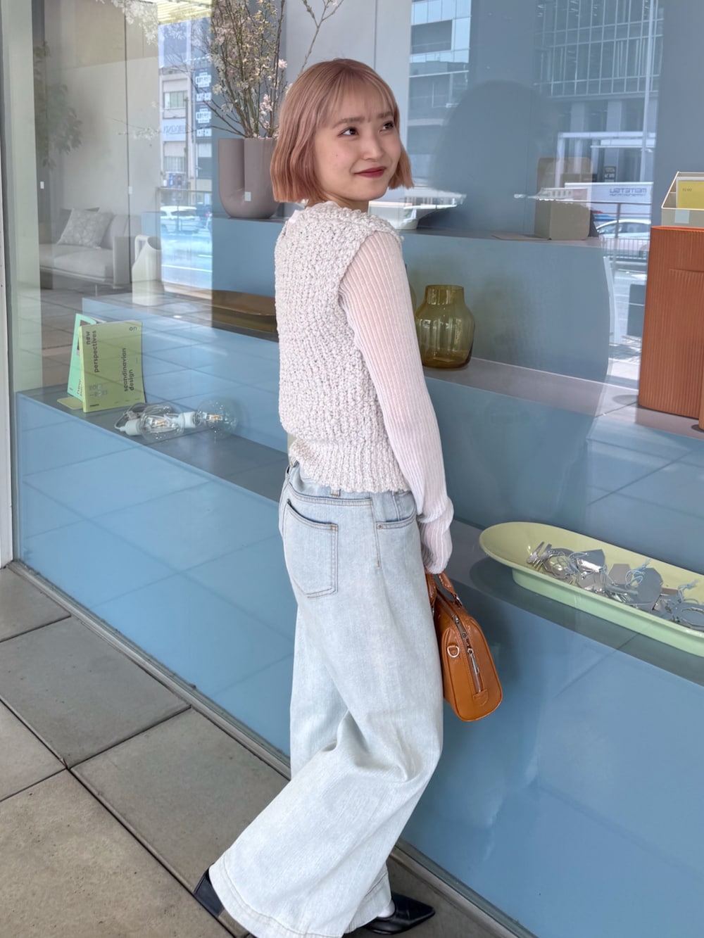 ホワイト系のベスト、ホワイト系のニット/セーター、ブルー系のデニムパンツを着用したレディースの春コーディネートの3枚目の写真