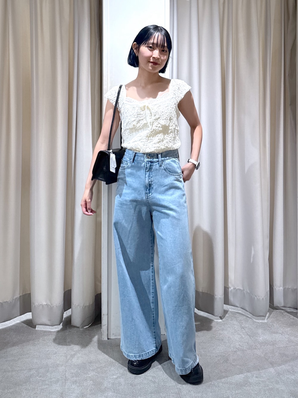 ホワイト系のTシャツ/カットソー、ブラック系のショルダーバッグ、ブルー系のデニムパンツを着用したレディースの夏コーディネートの4枚目の写真