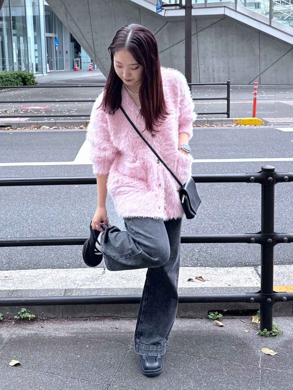 ブラック系のデニムパンツ、ピンク系のカーディガン/ボレロ、ホワイト系のキャミソールを着用したレディースの秋コーディネートの4枚目の写真