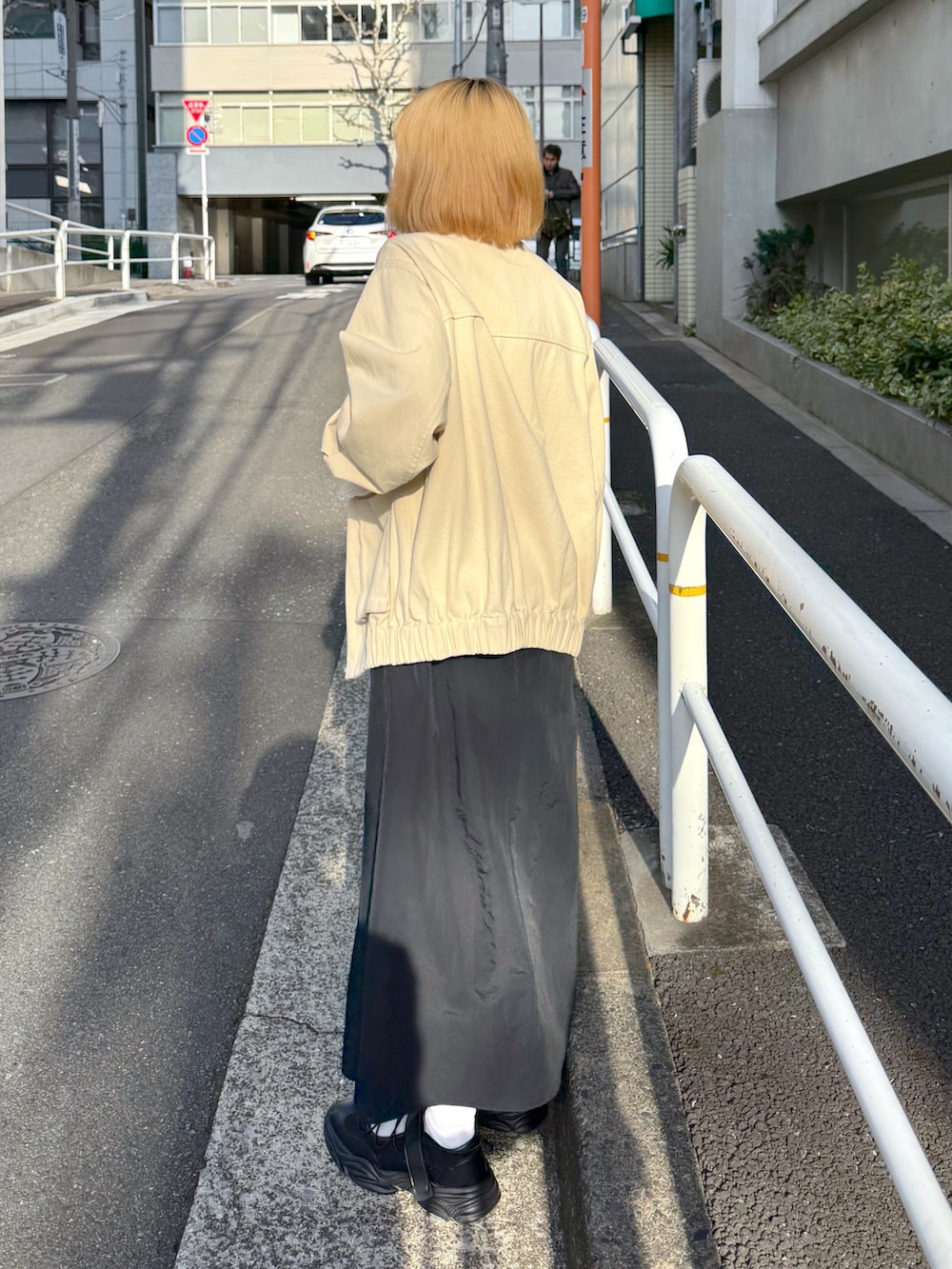 ホワイト系のその他アウター、ホワイト系のTシャツ/カットソー、ブラック系のジャンパースカートを着用したレディースの春コーディネートの3枚目の写真