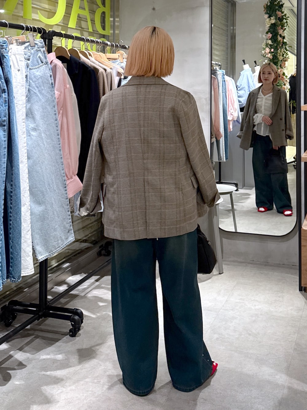 グレー系のテーラードジャケット、ホワイト系のシャツ/ブラウス、ブルー系のデニムパンツを着用したレディースの夏コーディネートの5枚目の写真