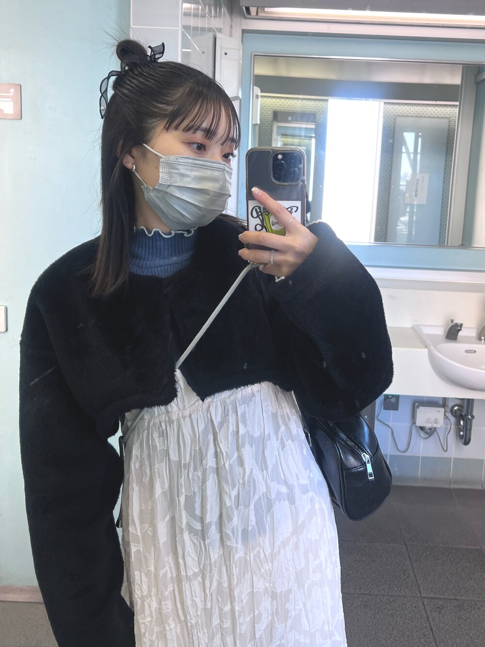 ブルー系のニット/セーター、ブラック系のブーツを着用したレディースの冬コーディネートの2枚目の写真