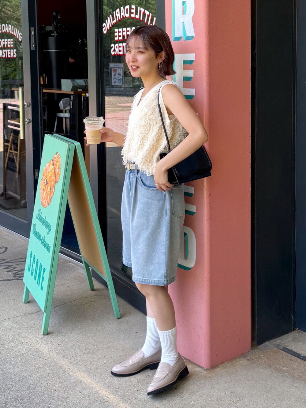 ホワイト系のニット/セーター、ブルー系のデニムパンツ、ベージュ系のローファーを着用したレディースの夏コーディネートの5枚目の写真