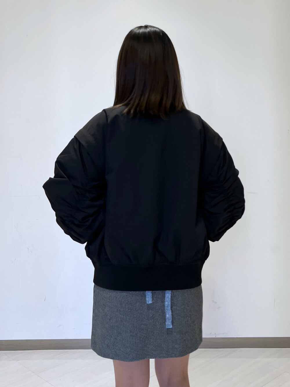 ブラック系のMA-1、ブルー系のニット/セーター、ブラック系のスカートを着用したレディースの冬コーディネートの3枚目の写真