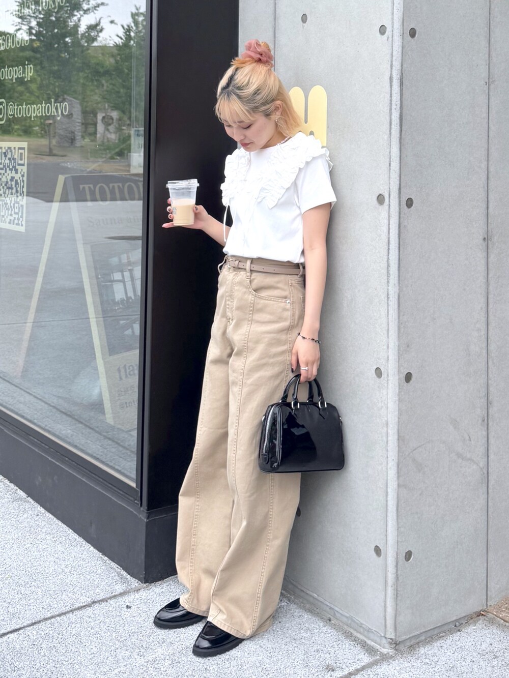 ホワイト系のTシャツ/カットソー、ベージュ系のその他パンツ、ブラック系のショルダーバッグを着用したレディースの春コーディネートの4枚目の写真