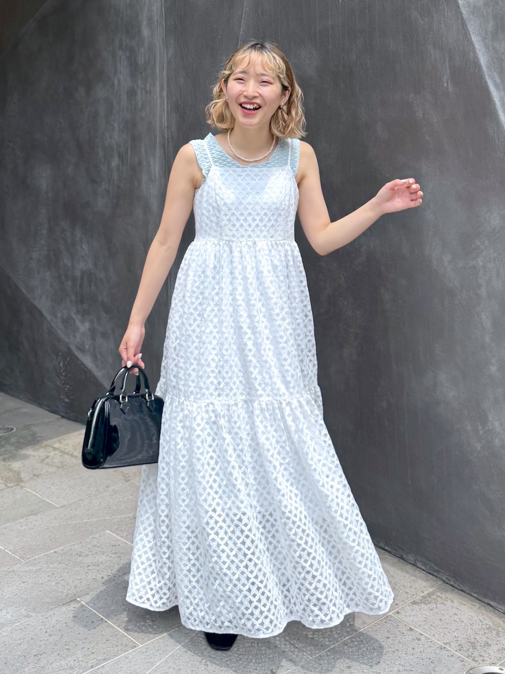 ブルー系のタンクトップ、ホワイト系のワンピース、ブルー系のデニムパンツを着用したレディースの夏コーディネートの2枚目の写真