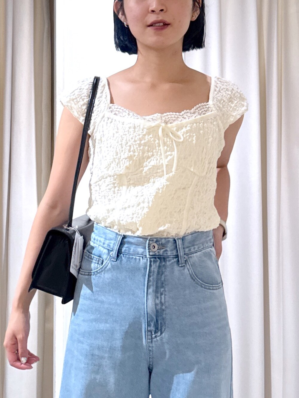 ホワイト系のTシャツ/カットソー、ブラック系のショルダーバッグ、ブルー系のデニムパンツを着用したレディースの夏コーディネートの3枚目の写真