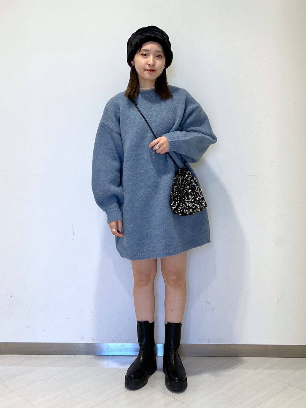 ブルー系のワンピース、ブラック系のハンドバッグ、ブラック系のハットを着用したレディースの冬コーディネートの2枚目の写真