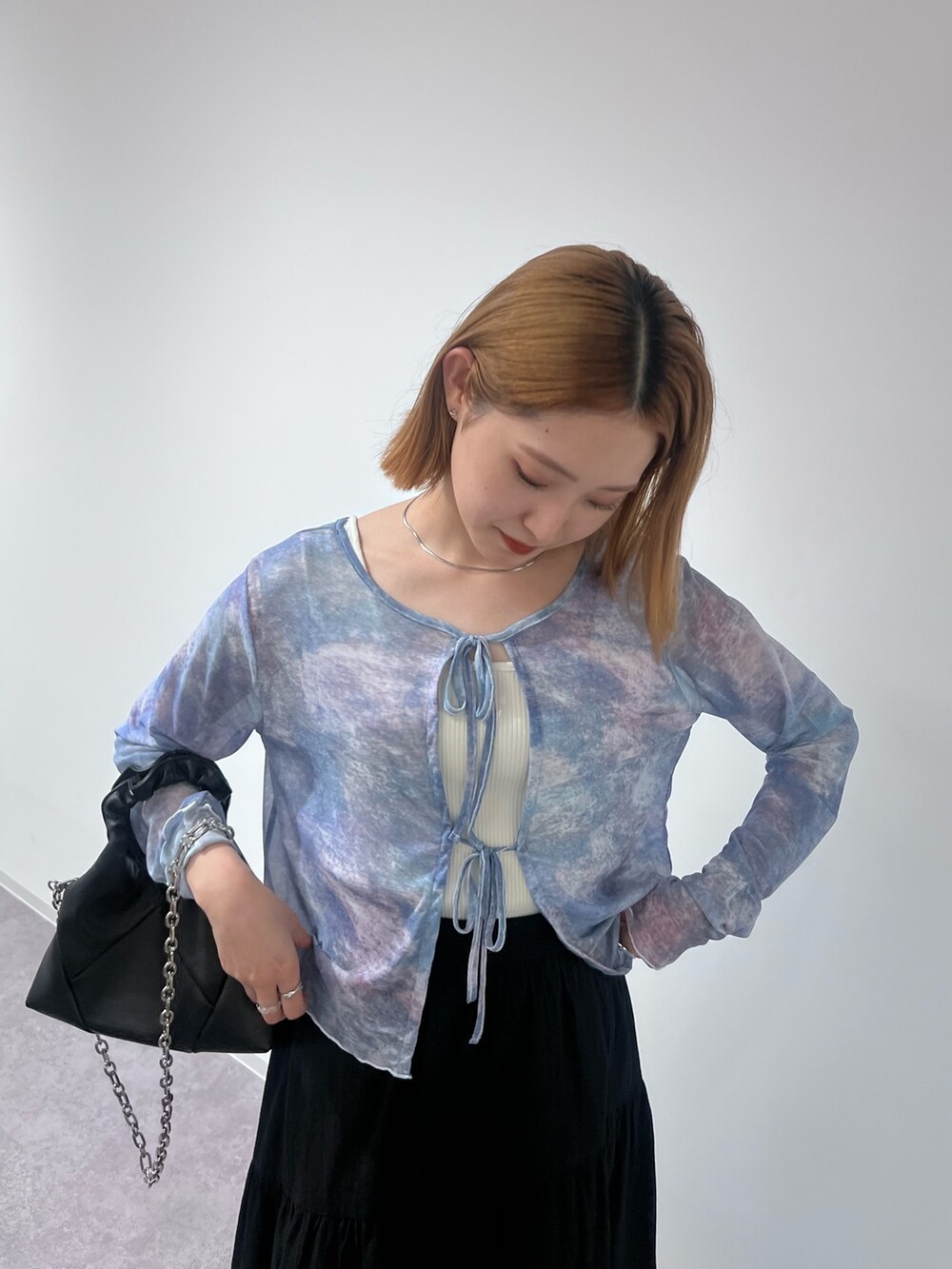 ブラック系のトートバッグ、ブラック系のスカート、ブラック系のサンダルを着用したレディースの夏コーディネートの6枚目の写真