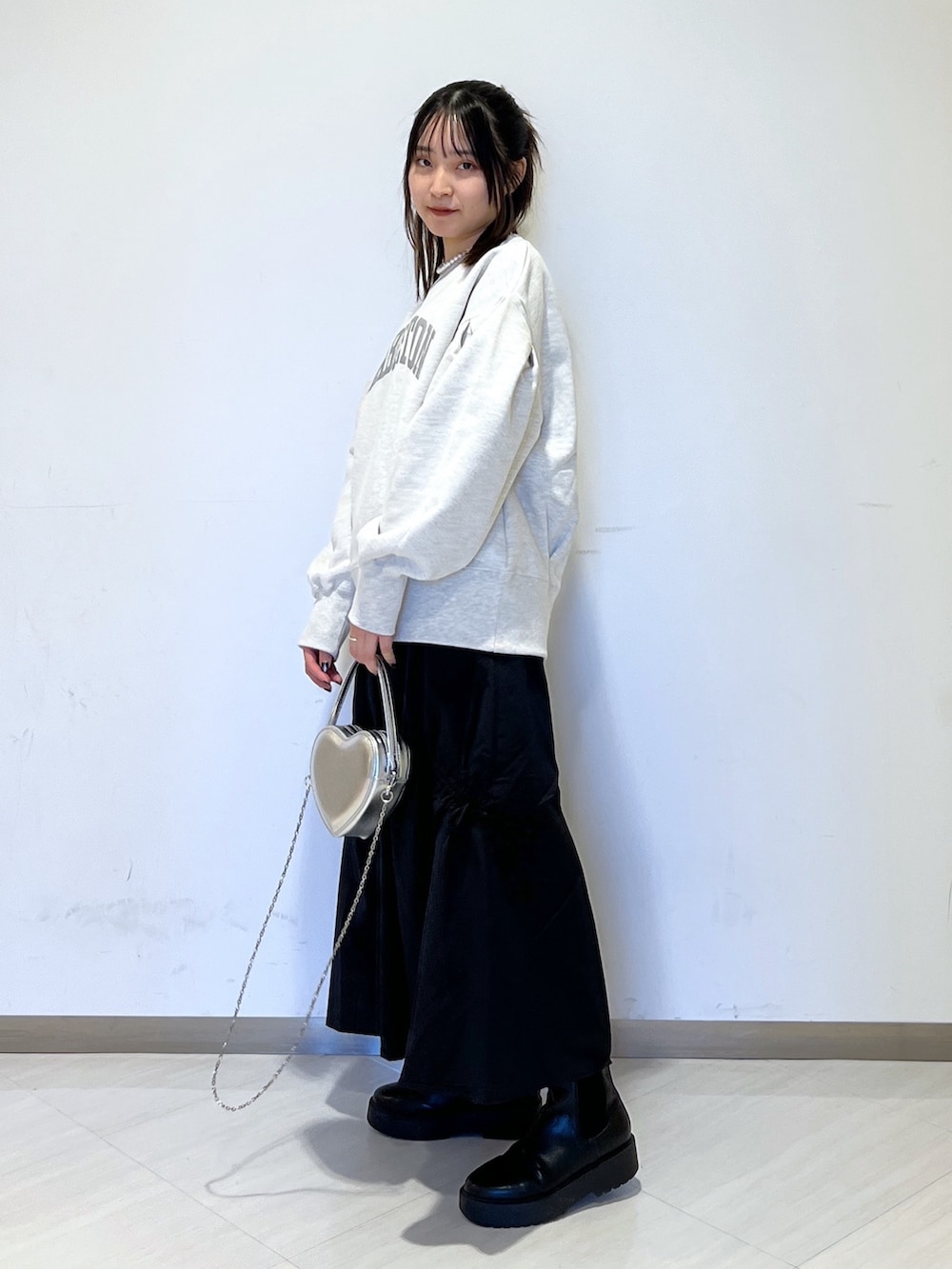 ホワイト系のスウェット、シルバー系のショルダーバッグ、ブラック系のスカートを着用したレディースの冬コーディネートの4枚目の写真