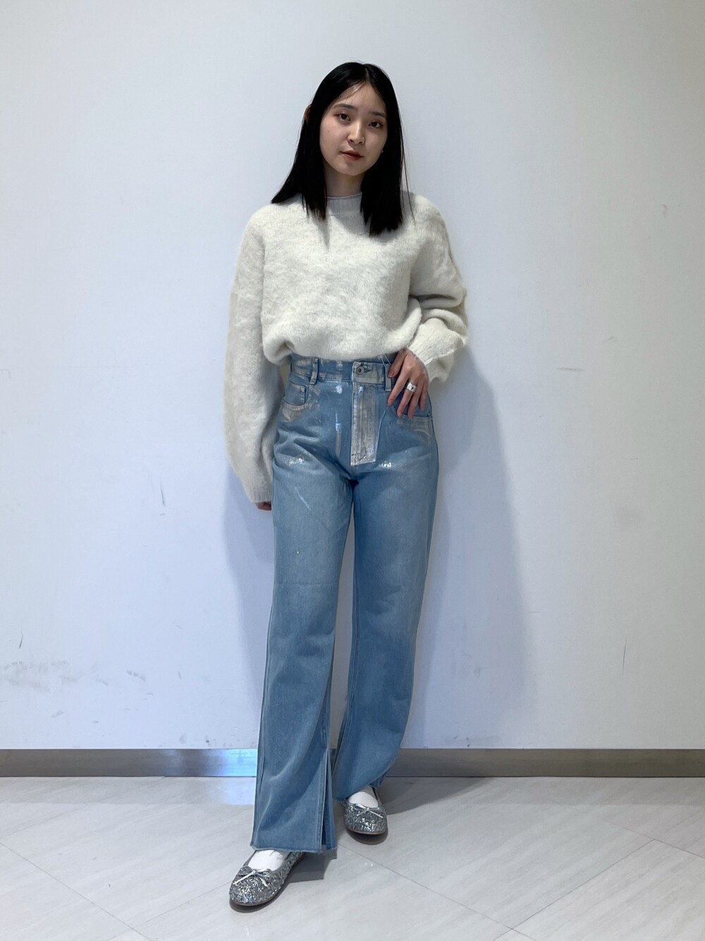 ホワイト系のMA-1、ホワイト系のニット/セーター、ブルー系のデニムパンツを着用したレディースの冬コーディネートの3枚目の写真