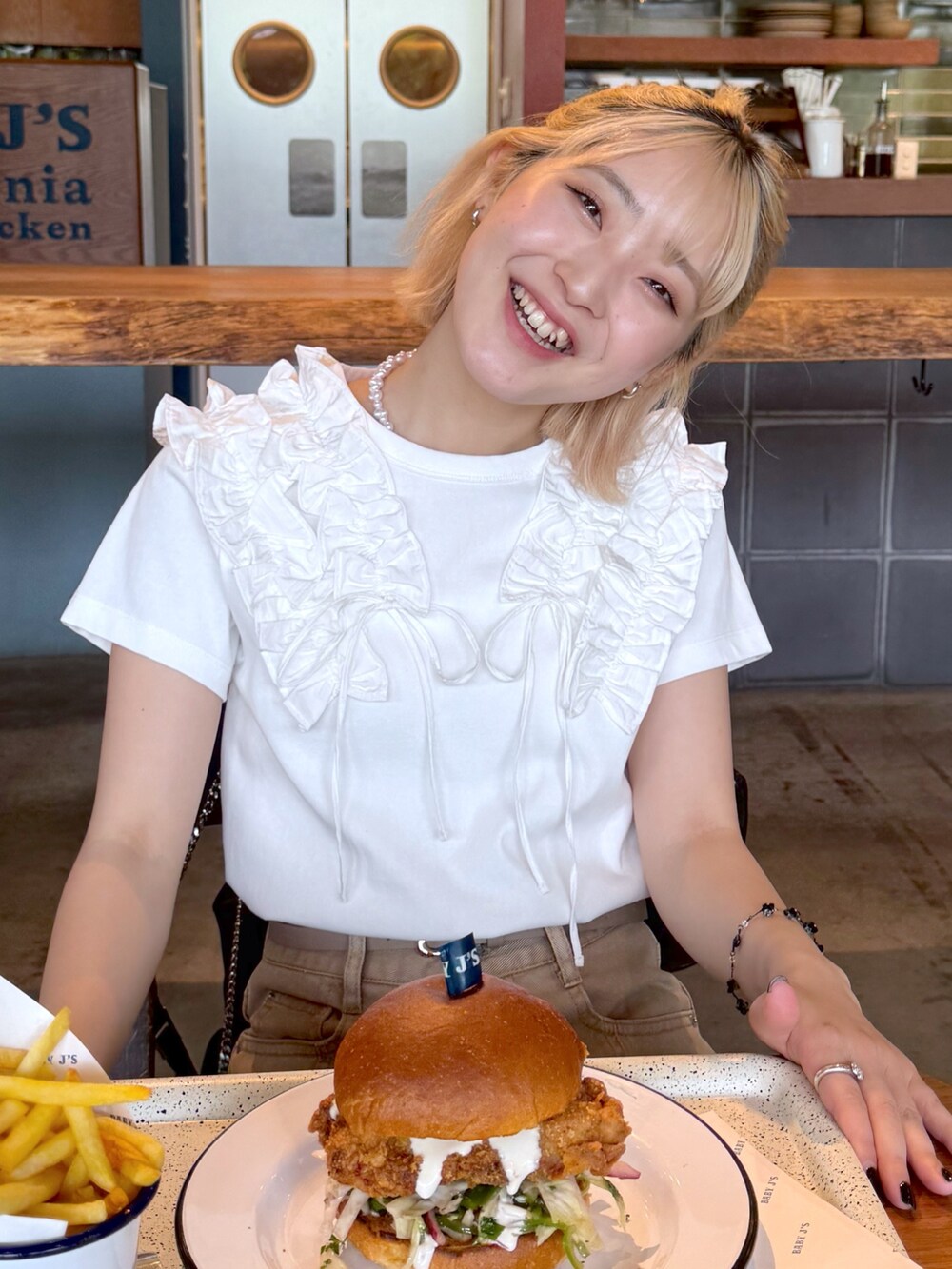 ホワイト系のTシャツ/カットソー、ベージュ系のその他パンツ、ブラック系のショルダーバッグを着用したレディースの春コーディネートの5枚目の写真