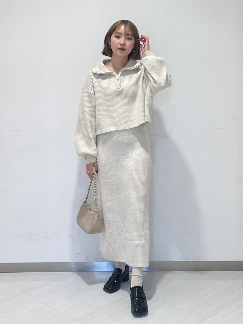 ホワイト系のワンピース、ベージュ系のトートバッグ、ブラック系のローファーを着用したレディースの冬コーディネートの2枚目の写真