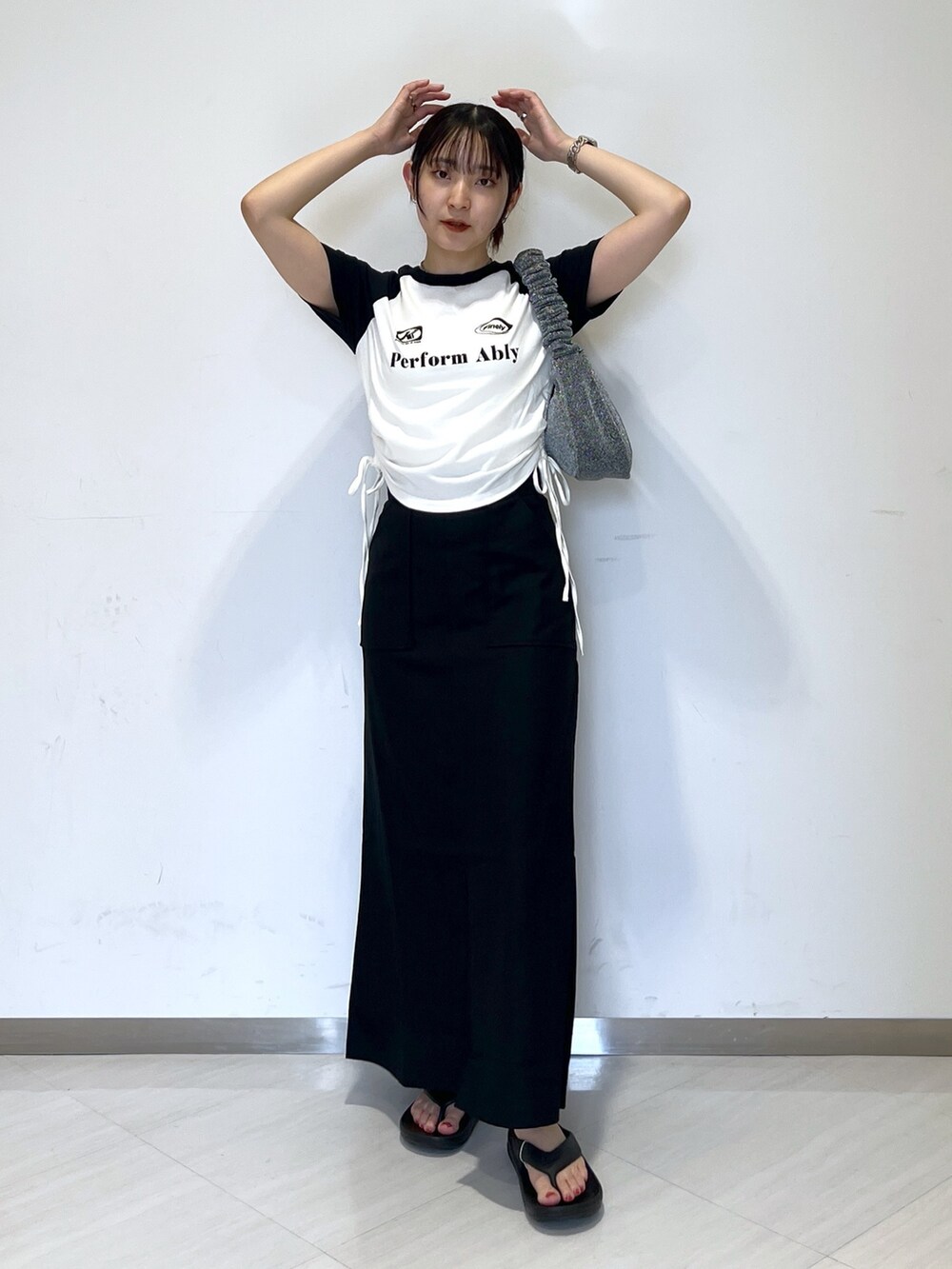 ホワイト系のTシャツ/カットソー、シルバー系のハンドバッグ、ブラック系のスカートを着用したレディースの夏コーディネートの2枚目の写真