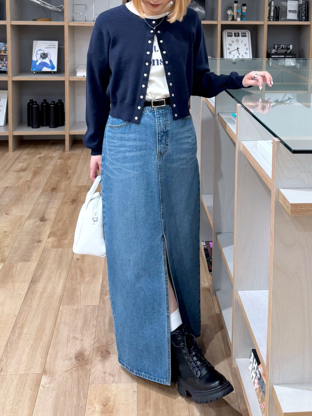 ブルー系のカーディガン/ボレロ、ホワイト系のTシャツ/カットソー、ブルー系のデニムスカートを着用したレディースの春コーディネートの2枚目の写真