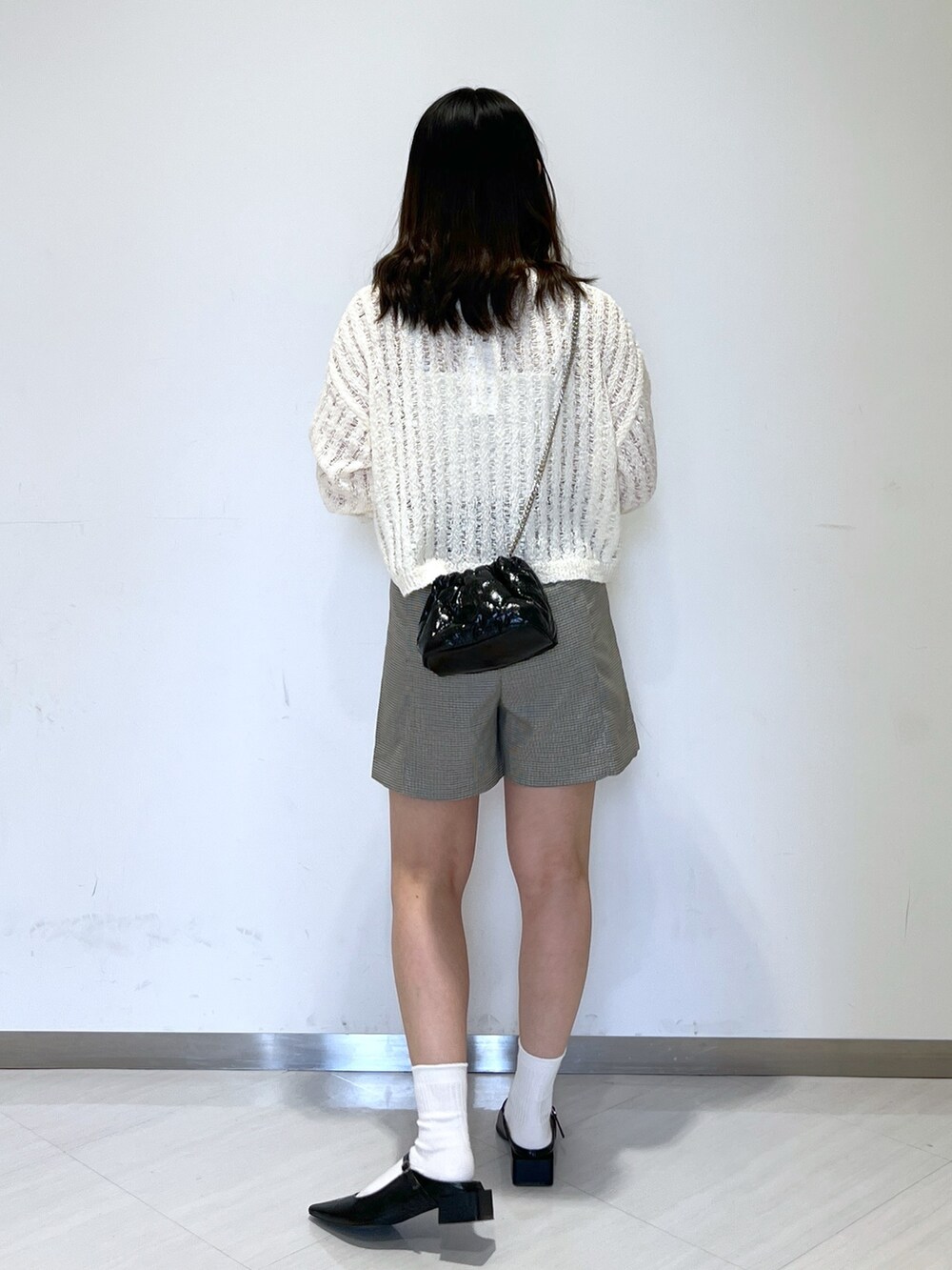 ホワイト系のニット/セーター、ブラック系のショルダーバッグ、ホワイト系のその他パンツを着用したレディースの春コーディネートの4枚目の写真