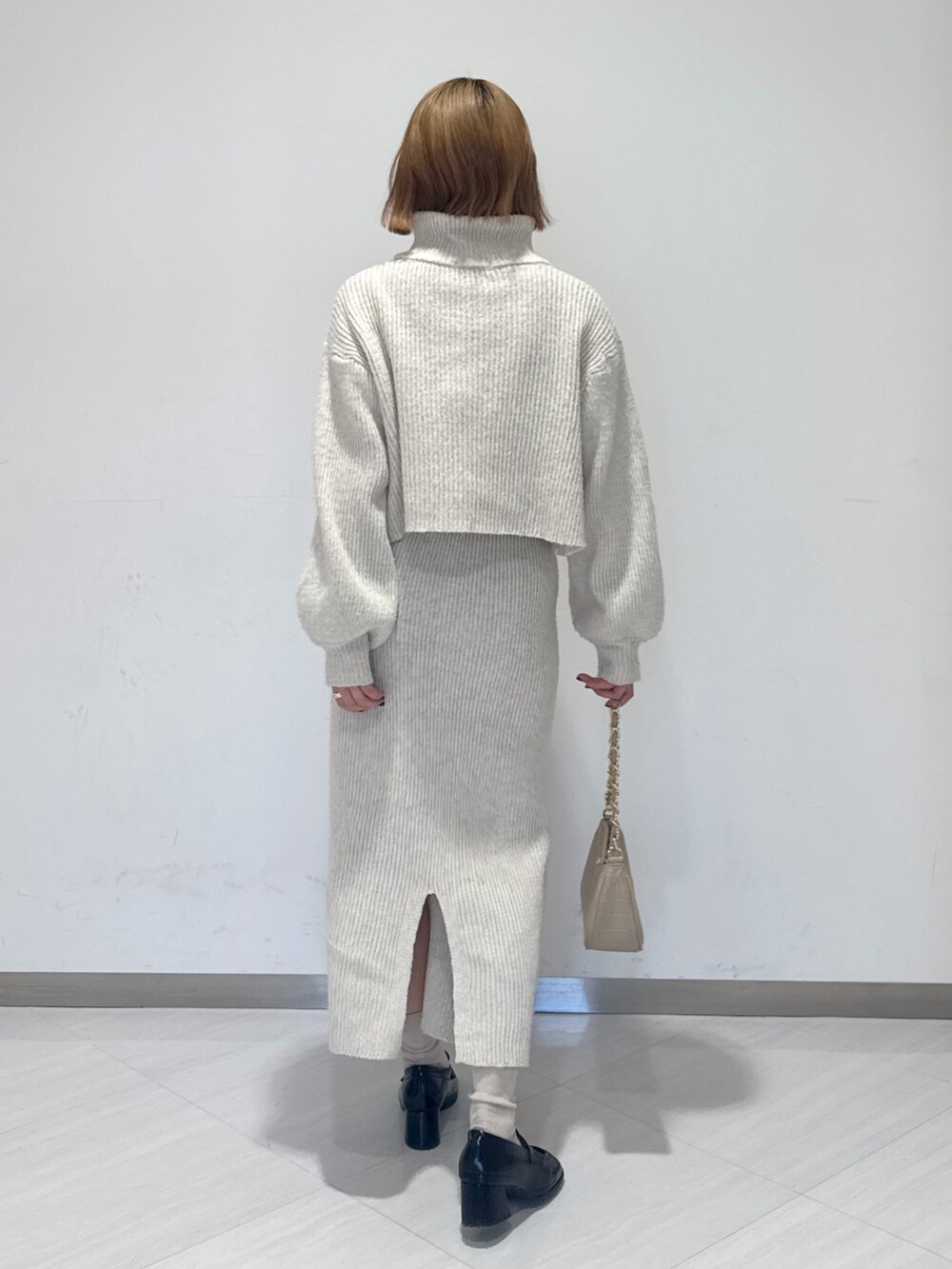 ホワイト系のワンピース、ベージュ系のトートバッグ、ブラック系のローファーを着用したレディースの冬コーディネートの4枚目の写真