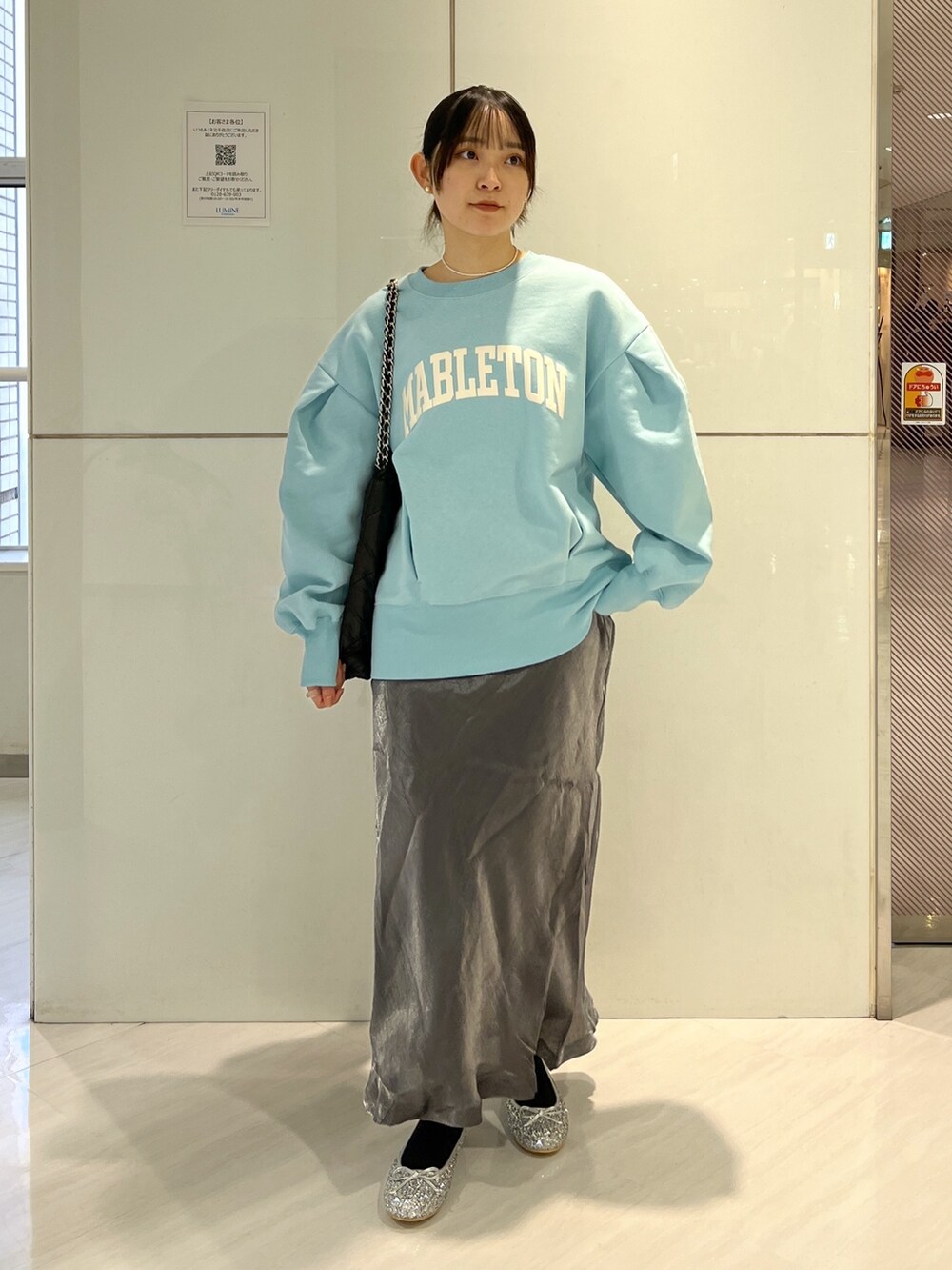 ブラック系のトートバッグ、ブラック系のスカート、ブルー系のスウェットを着用したレディースの冬コーディネートの2枚目の写真