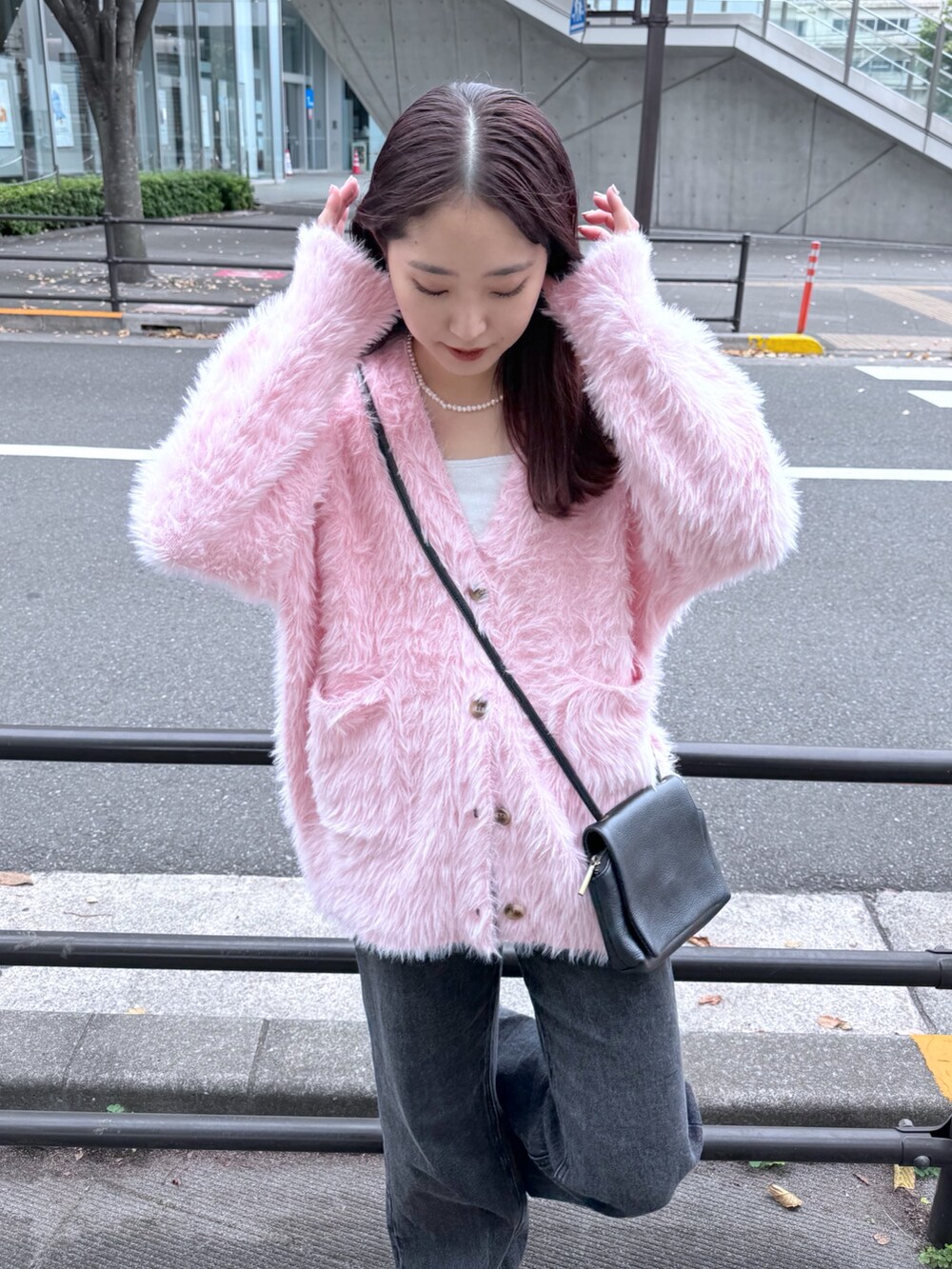 ブラック系のデニムパンツ、ピンク系のカーディガン/ボレロ、ホワイト系のキャミソールを着用したレディースの秋コーディネートの3枚目の写真