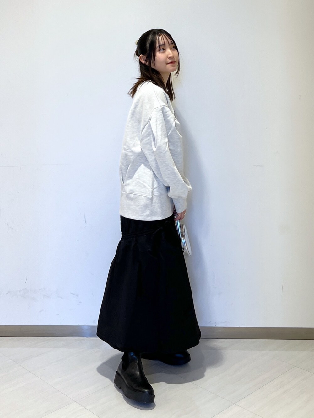 ホワイト系のスウェット、シルバー系のショルダーバッグ、ブラック系のスカートを着用したレディースの冬コーディネートの3枚目の写真