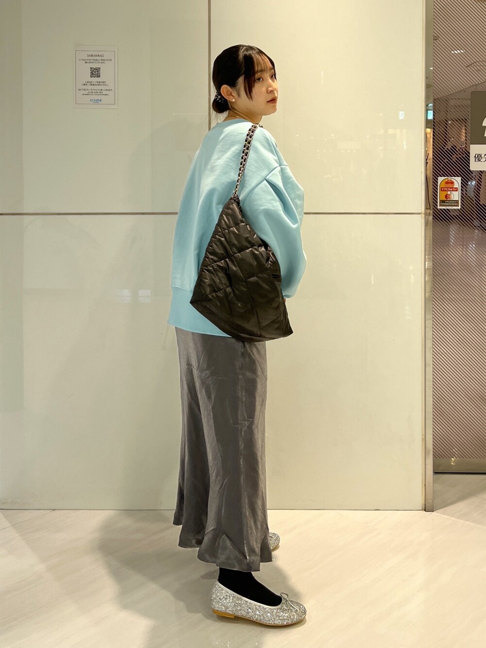 ブラック系のトートバッグ、ブラック系のスカート、ブルー系のスウェットを着用したレディースの冬コーディネートの4枚目の写真