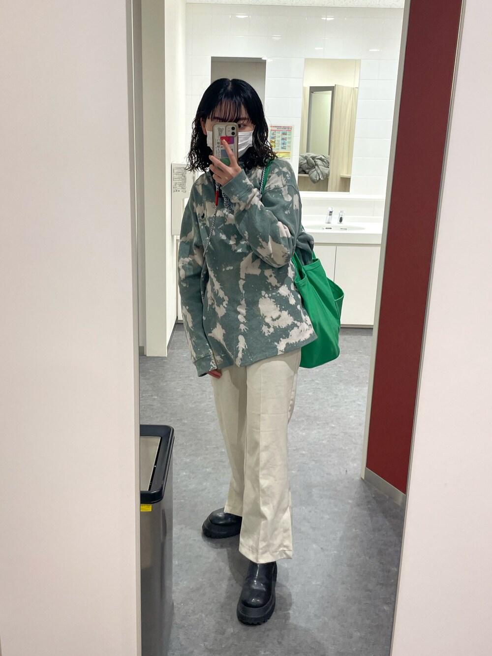 ホワイト系のスラックス、ブラック系のブーツ、ブルー系のトップスを着用したレディースの冬コーディネートの2枚目の写真