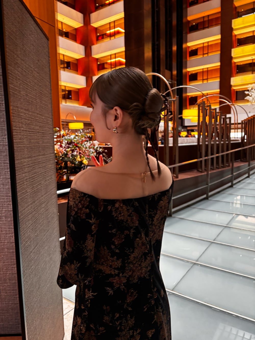 ブラック系のパンプス、ブラック系のドレス、ベージュ系のトレンチコートを着用したレディースの秋コーディネートの2枚目の写真