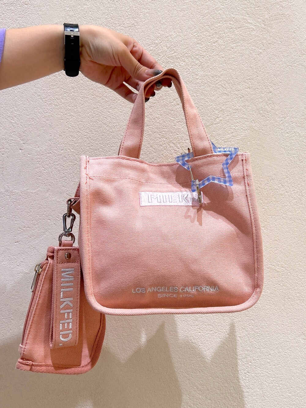 パープル系のTシャツ/カットソー、ブラック系のスカート、ピンク系のショルダーバッグを着用したレディースの夏コーディネートの4枚目の写真