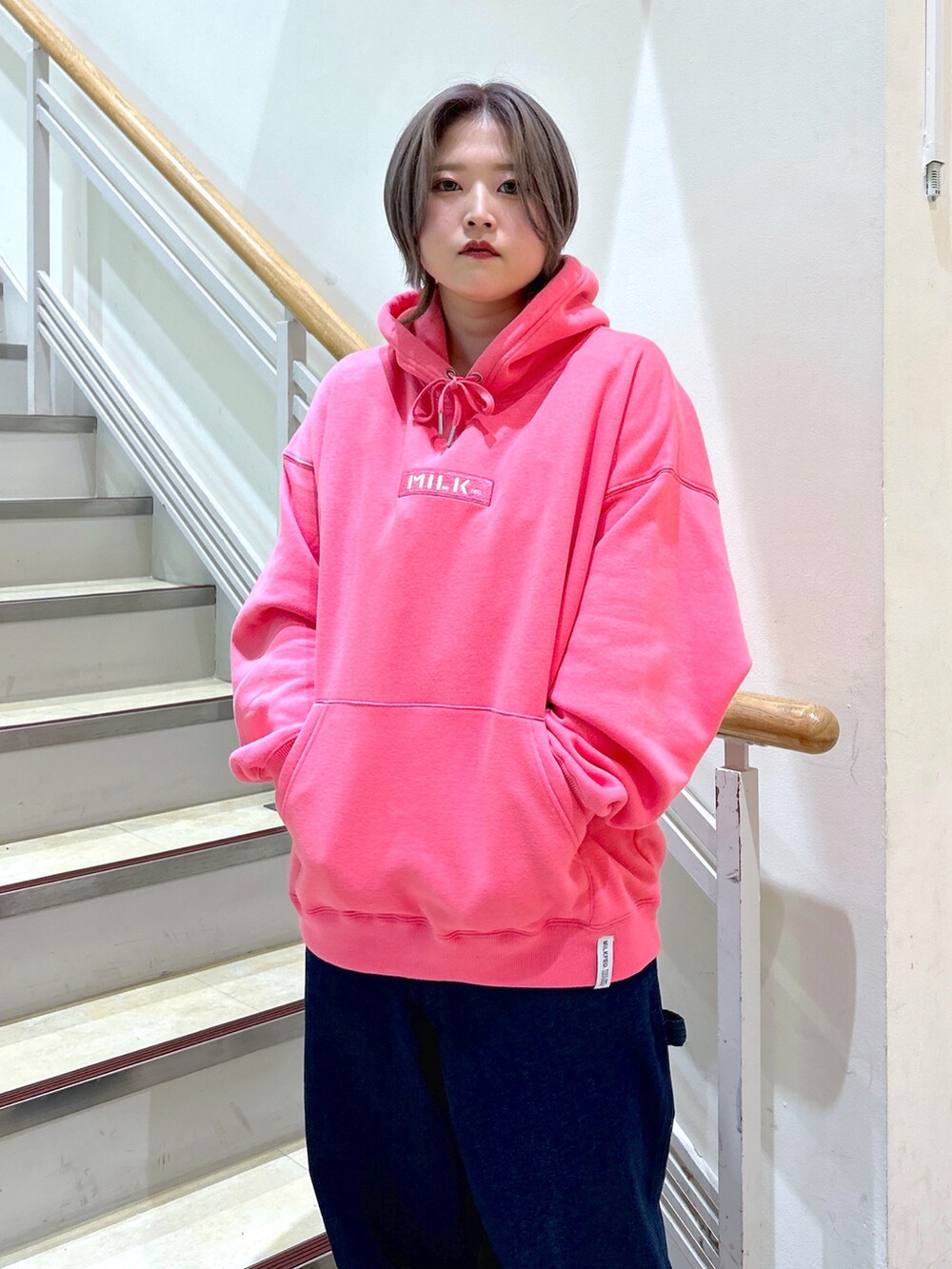 ピンク系のパーカー、ブラック系のショルダーバッグ、ブルー系のサロペット/オーバーオールを着用したレディースの秋コーディネートの3枚目の写真