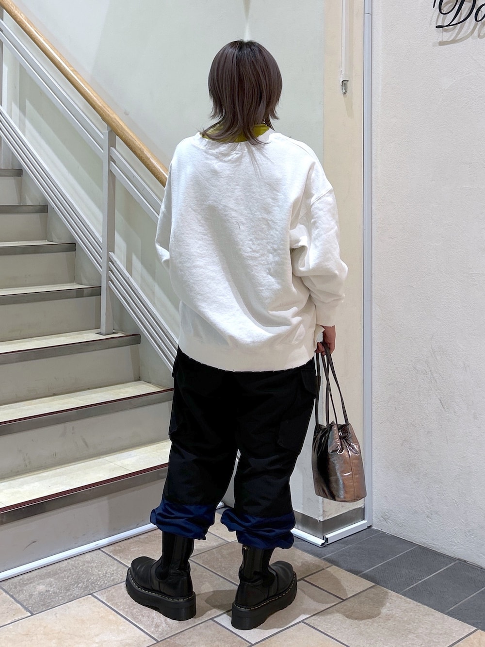 ブラック系のカーゴパンツ、シルバー系のショルダーバッグ、ブラック系のブーツを着用したレディースの冬コーディネートの3枚目の写真