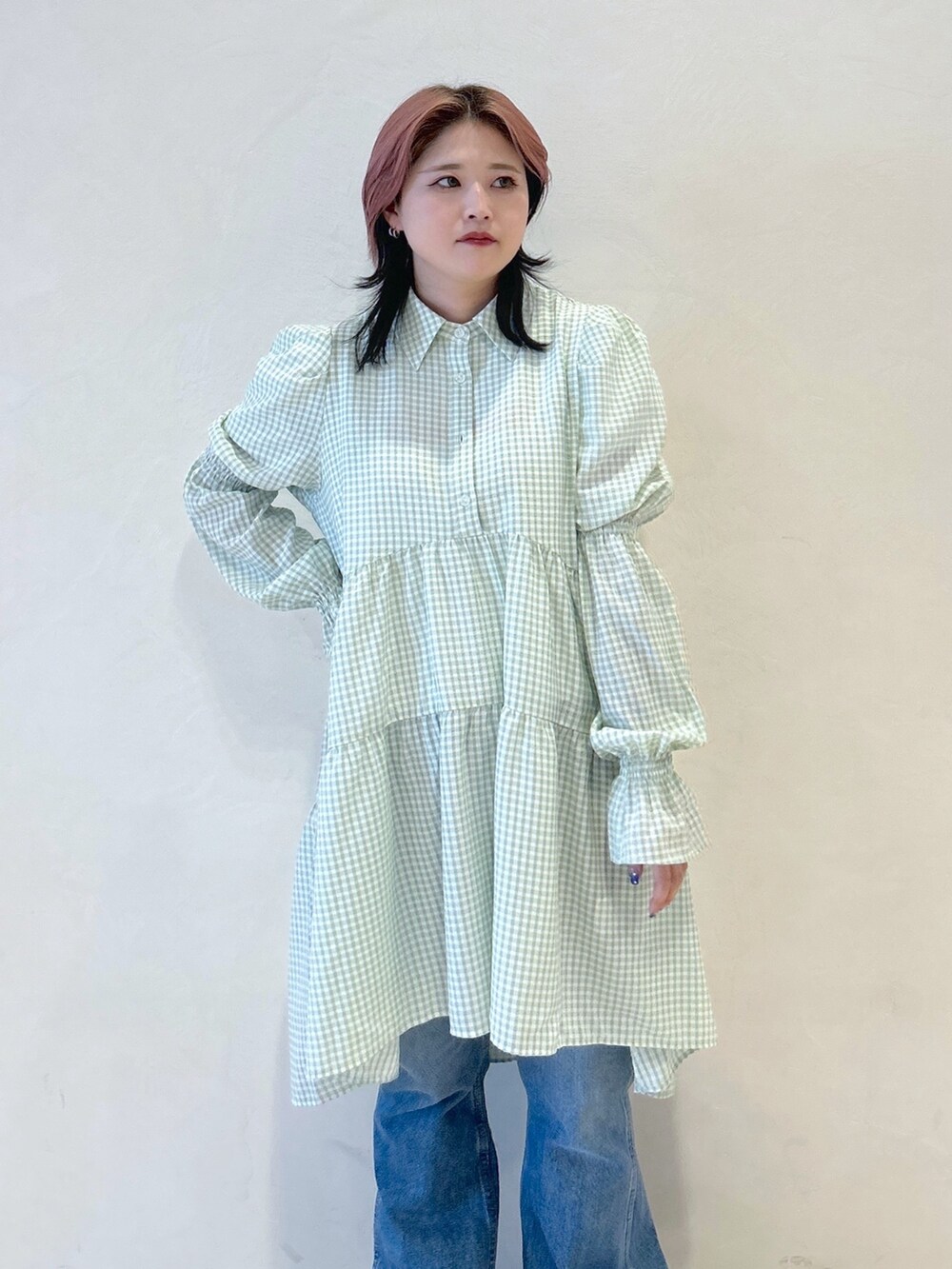 グリーン系のワンピース、ブルー系のデニムパンツ、ブラック系のトートバッグを着用したレディースの夏コーディネートの5枚目の写真