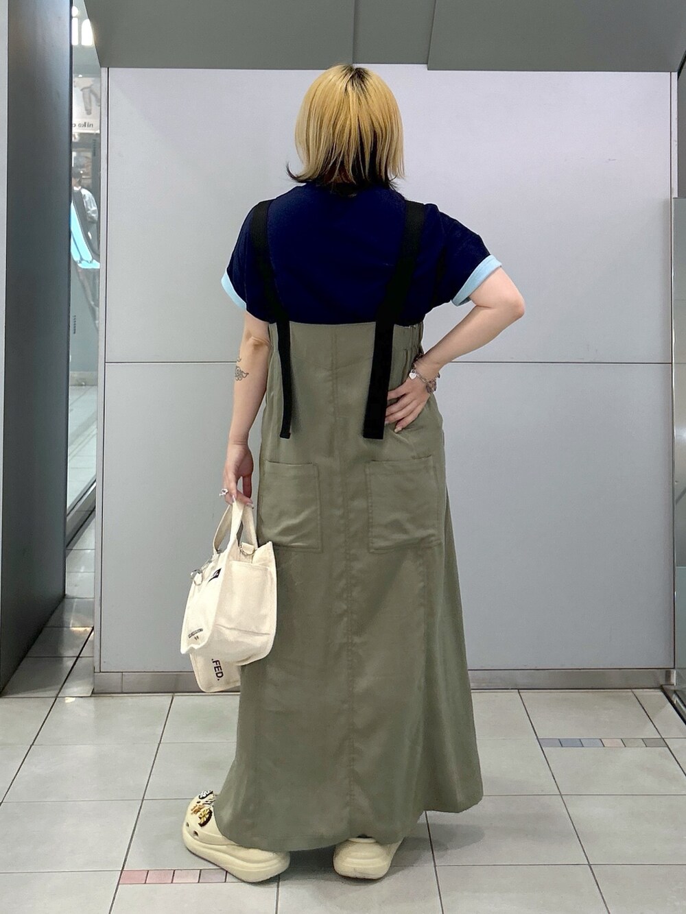 ブルー系のTシャツ/カットソー、グリーン系のワンピース、ホワイト系のショルダーバッグを着用したレディースの春コーディネートの4枚目の写真