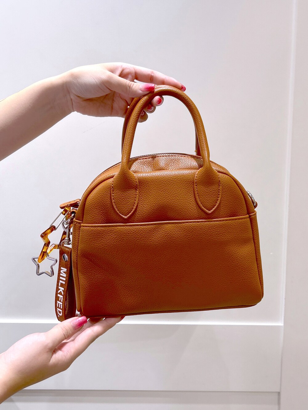 パープル系のシャツ/ブラウス、ブラック系のスカート、ブラウン系のボストンバッグを着用したレディースの夏コーディネートの5枚目の写真