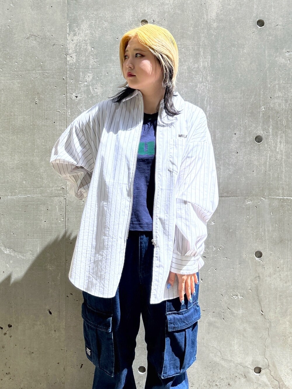 ブルー系のTシャツ/カットソー、ブラウン系のボストンバッグ、ブルー系のカーゴパンツを着用したレディースの春コーディネートの5枚目の写真