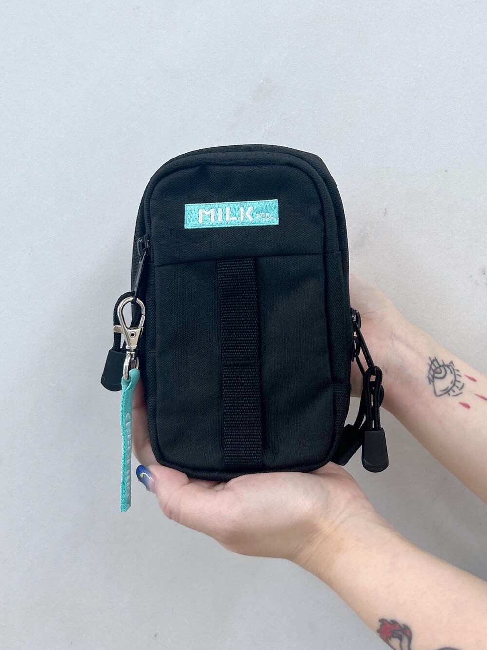 ホワイト系のワンピース、ブラック系のブーツ、グリーン系のショルダーバッグを着用したレディースの夏コーディネートの7枚目の写真