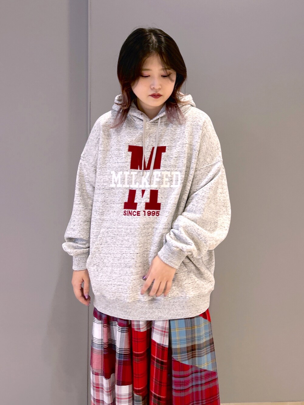 その他のパーカー、レッド系のスカート、レッド系のトートバッグを着用したレディースの秋コーディネートの3枚目の写真