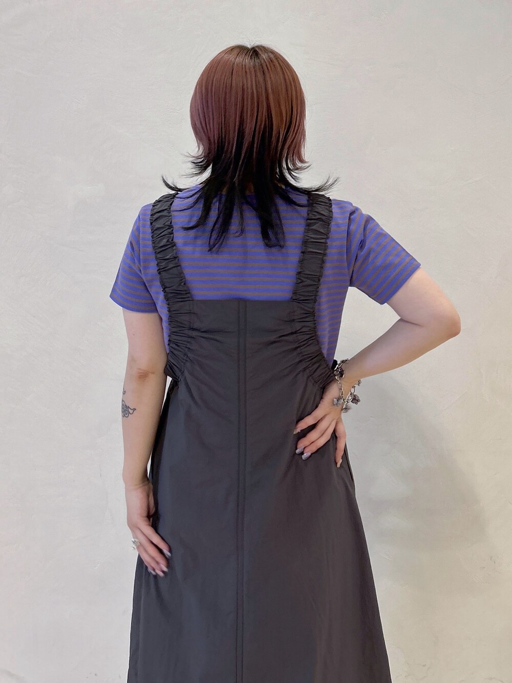 パープル系のTシャツ/カットソー、グレー系のワンピース、ブラック系のショルダーバッグを着用したレディースの春コーディネートの6枚目の写真