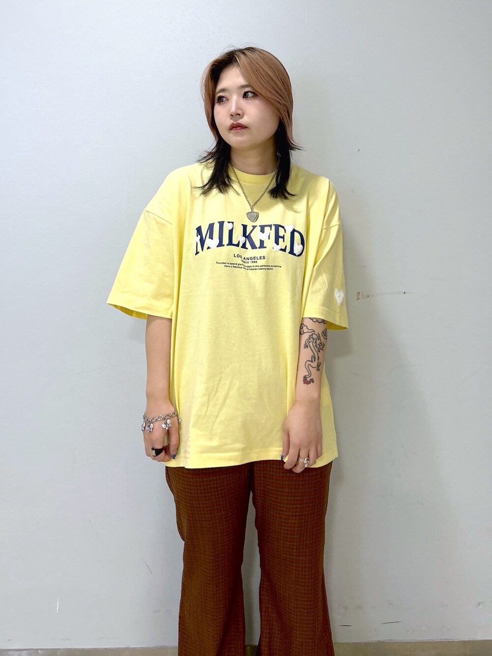 オレンジ系のその他パンツ、ブラウン系のショルダーバッグ、イエロー系のTシャツ/カットソーを着用したレディースの夏コーディネートの5枚目の写真