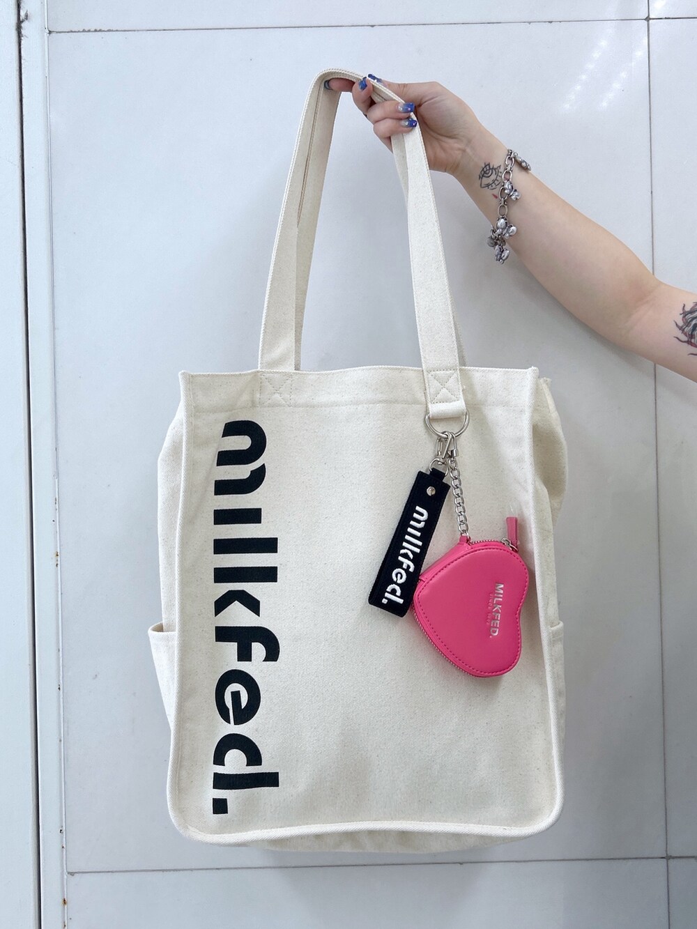 イエロー系のTシャツ/カットソー、ブラック系のワンピース、ホワイト系のショルダーバッグを着用したレディースの夏コーディネートの7枚目の写真