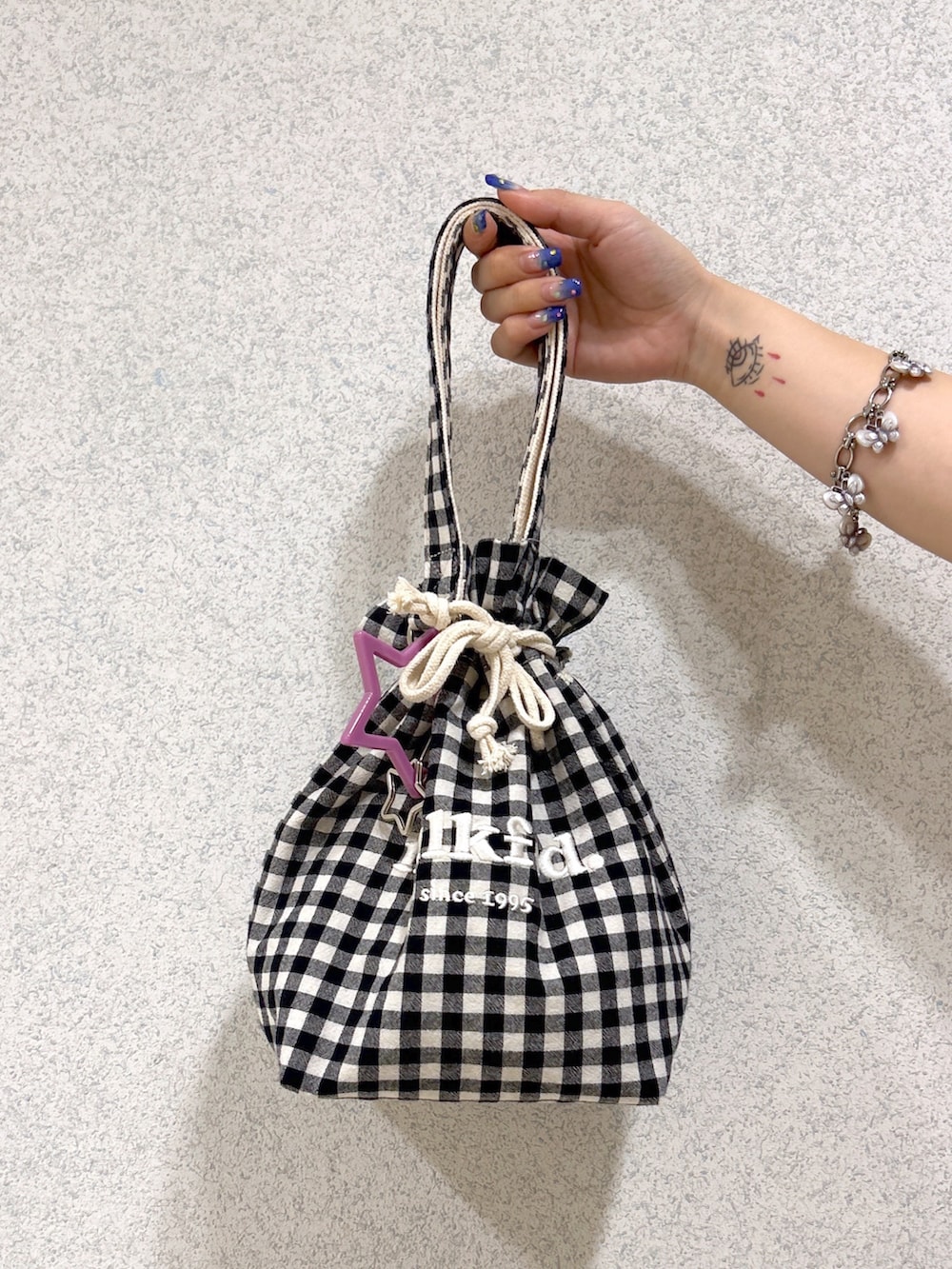 ブルー系のデニムパンツ、パープル系のタンクトップ、ブラック系のカーディガン/ボレロを着用したレディースの夏コーディネートの7枚目の写真