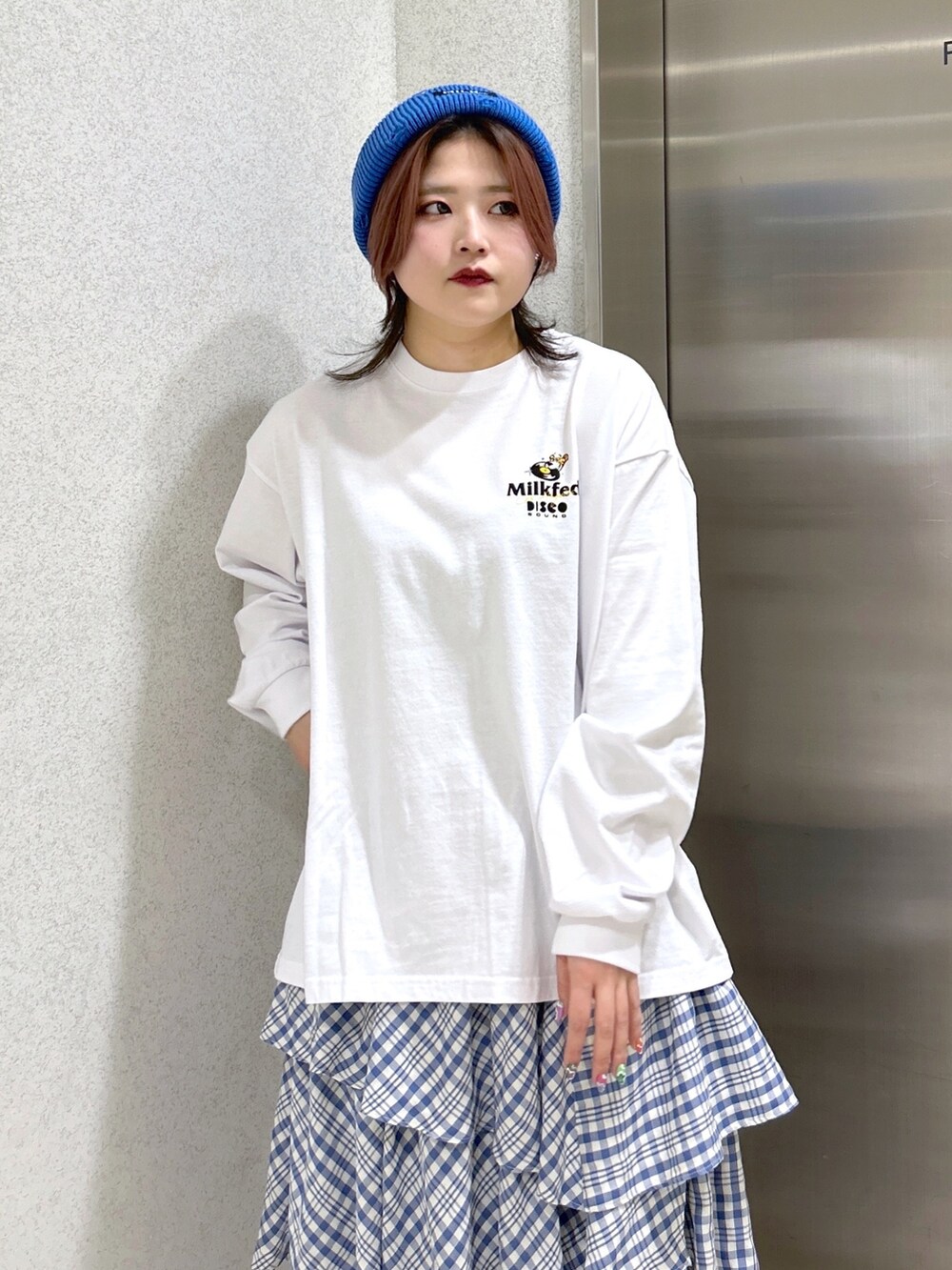 ホワイト系のTシャツ/カットソー、ブルー系のスカート、ブラック系のショルダーバッグを着用したレディースの冬コーディネートの3枚目の写真