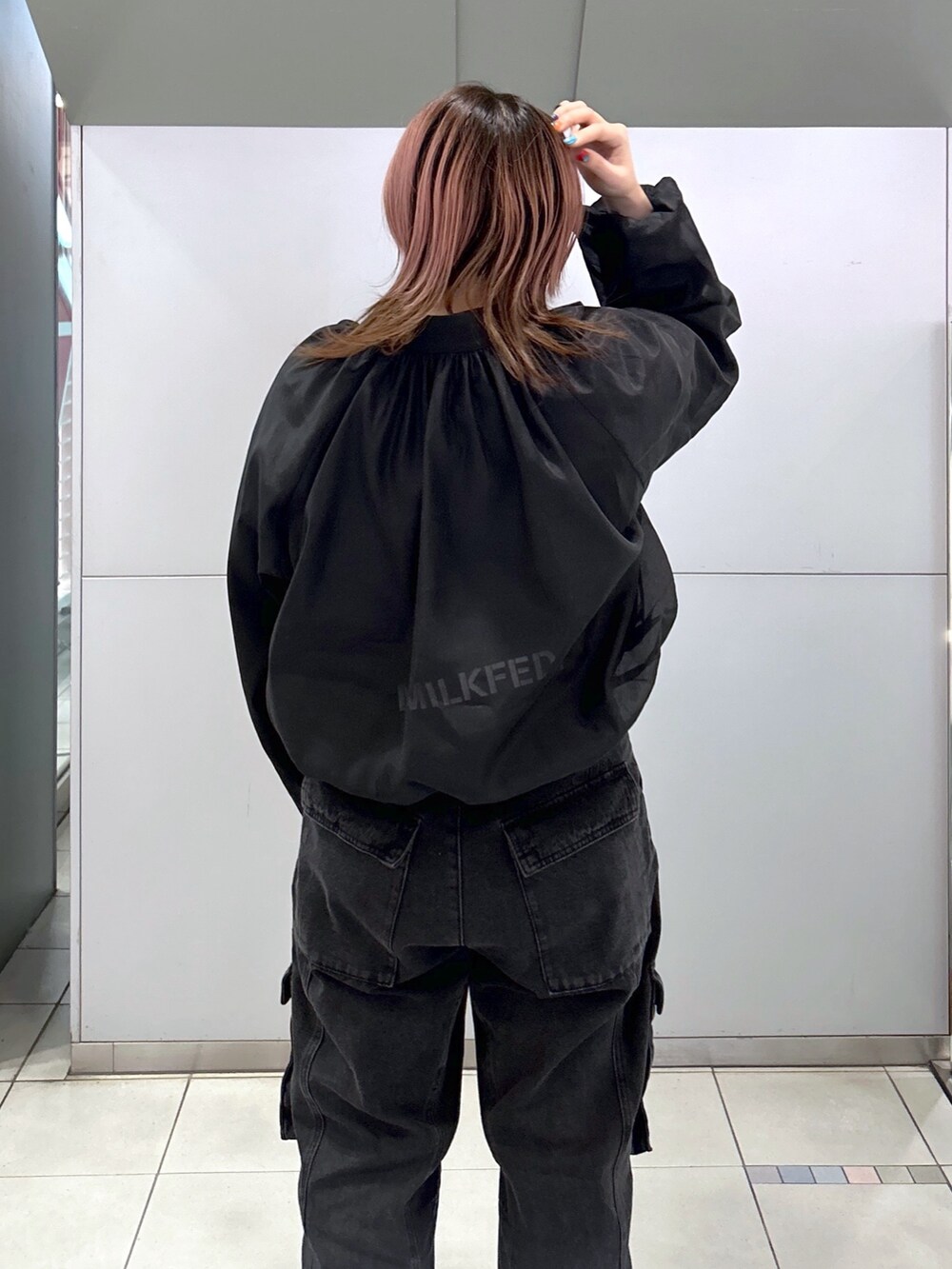 ブラック系のブルゾン、ブラック系のカーゴパンツ、ブラウン系のショルダーバッグを着用したレディースの春コーディネートの4枚目の写真