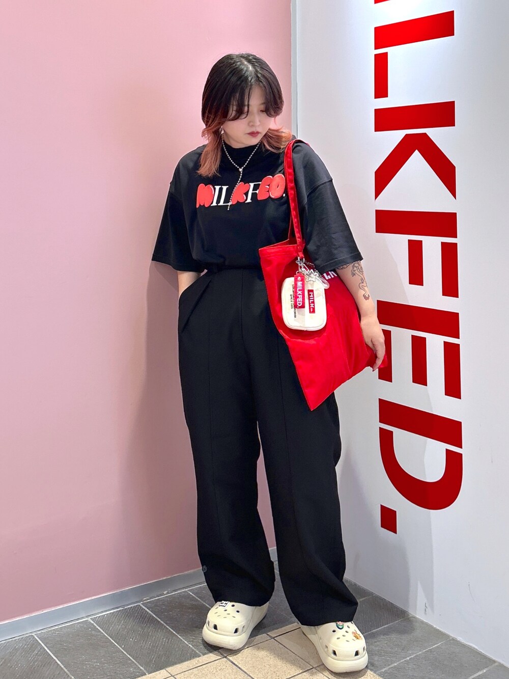 ブラック系のTシャツ/カットソー、レッド系のトートバッグ、ブラック系のその他パンツを着用したレディースの夏コーディネートの2枚目の写真