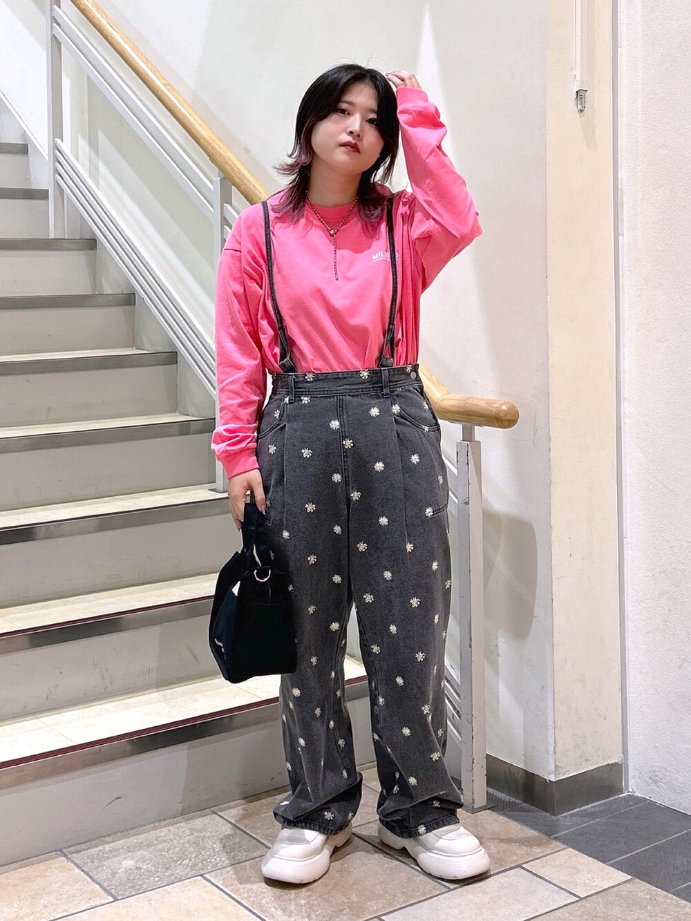 ピンク系のTシャツ/カットソー、ブラック系のデニムパンツ、ピンク系のショルダーバッグを着用したレディースの夏コーディネートの3枚目の写真