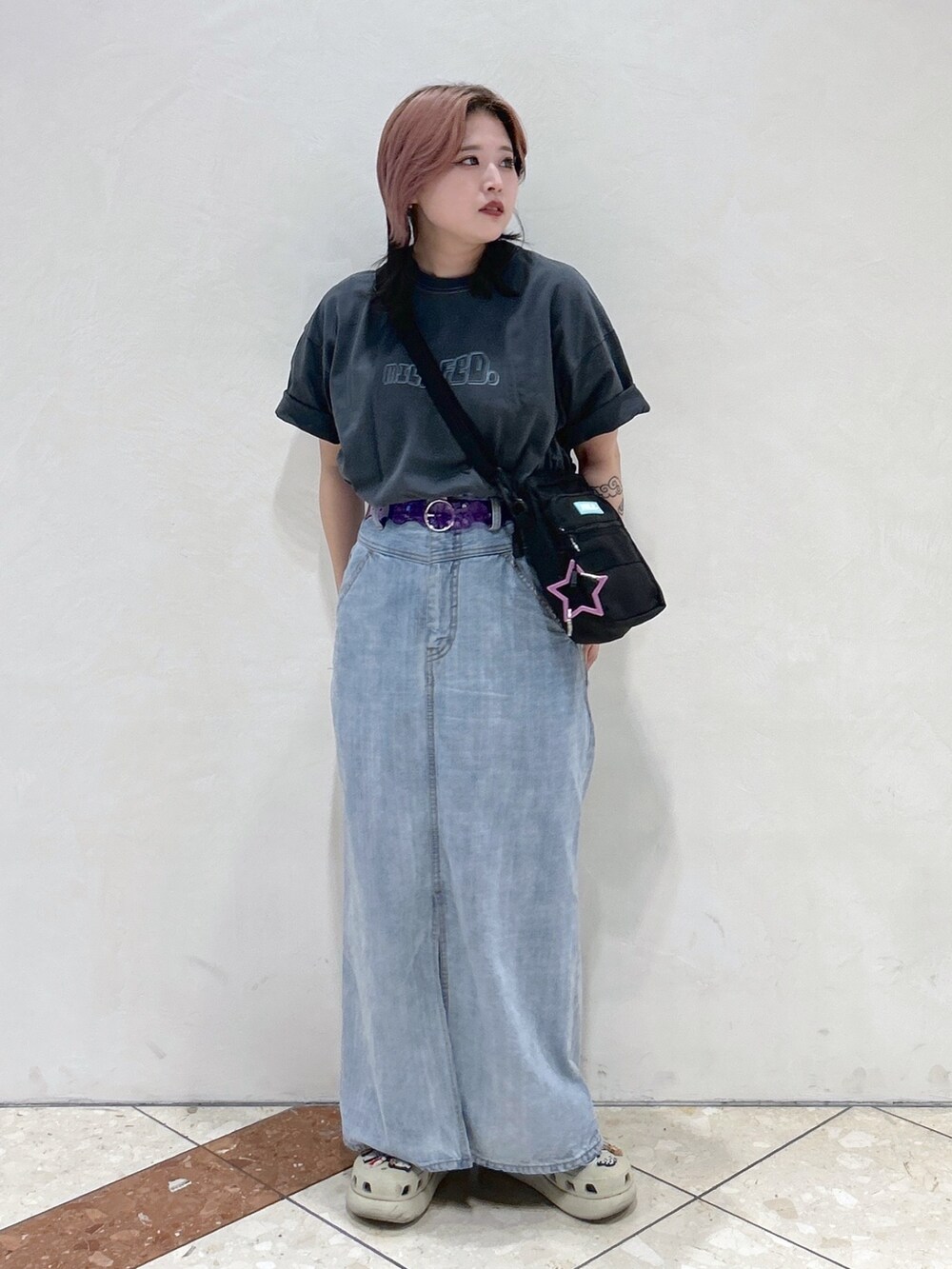 グレー系のTシャツ/カットソー、グリーン系のショルダーバッグ、ブルー系のデニムスカートを着用したレディースの夏コーディネートの2枚目の写真