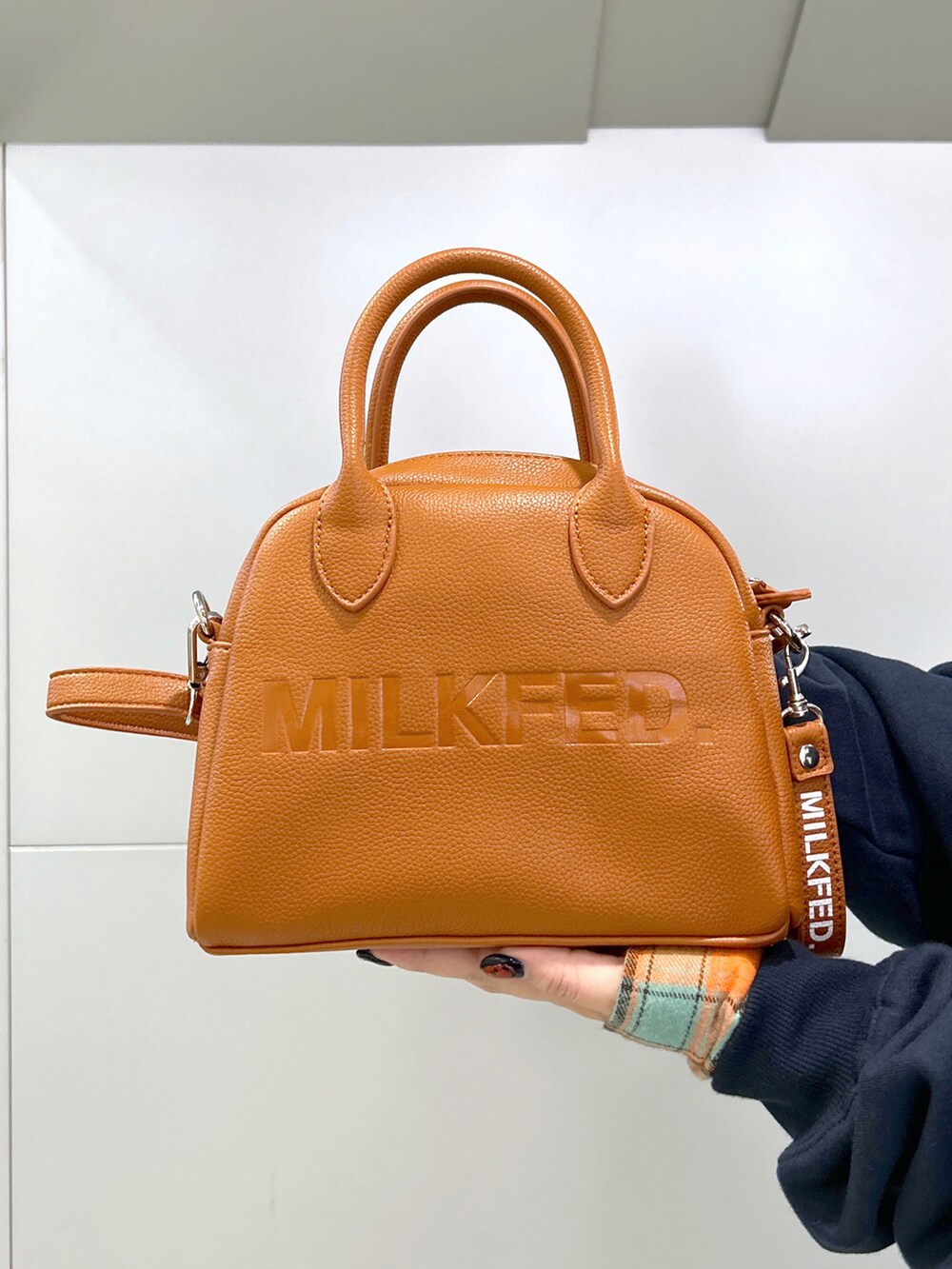 ブルー系のスウェット、ブラウン系のボストンバッグ、グリーン系のシャツワンピースを着用したレディースの秋コーディネートの5枚目の写真