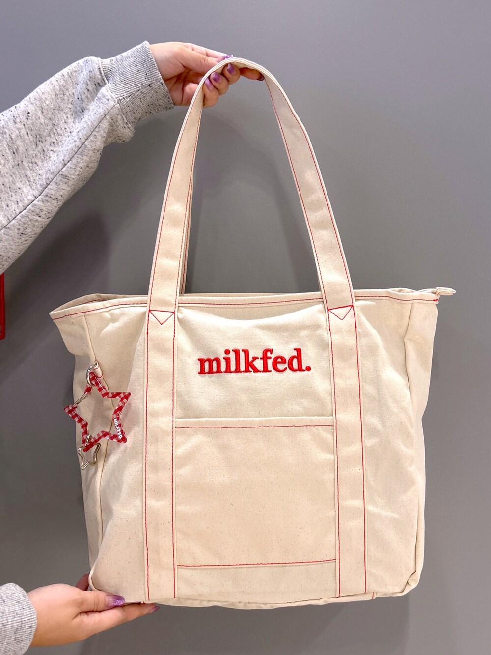 その他のパーカー、レッド系のスカート、レッド系のトートバッグを着用したレディースの秋コーディネートの4枚目の写真